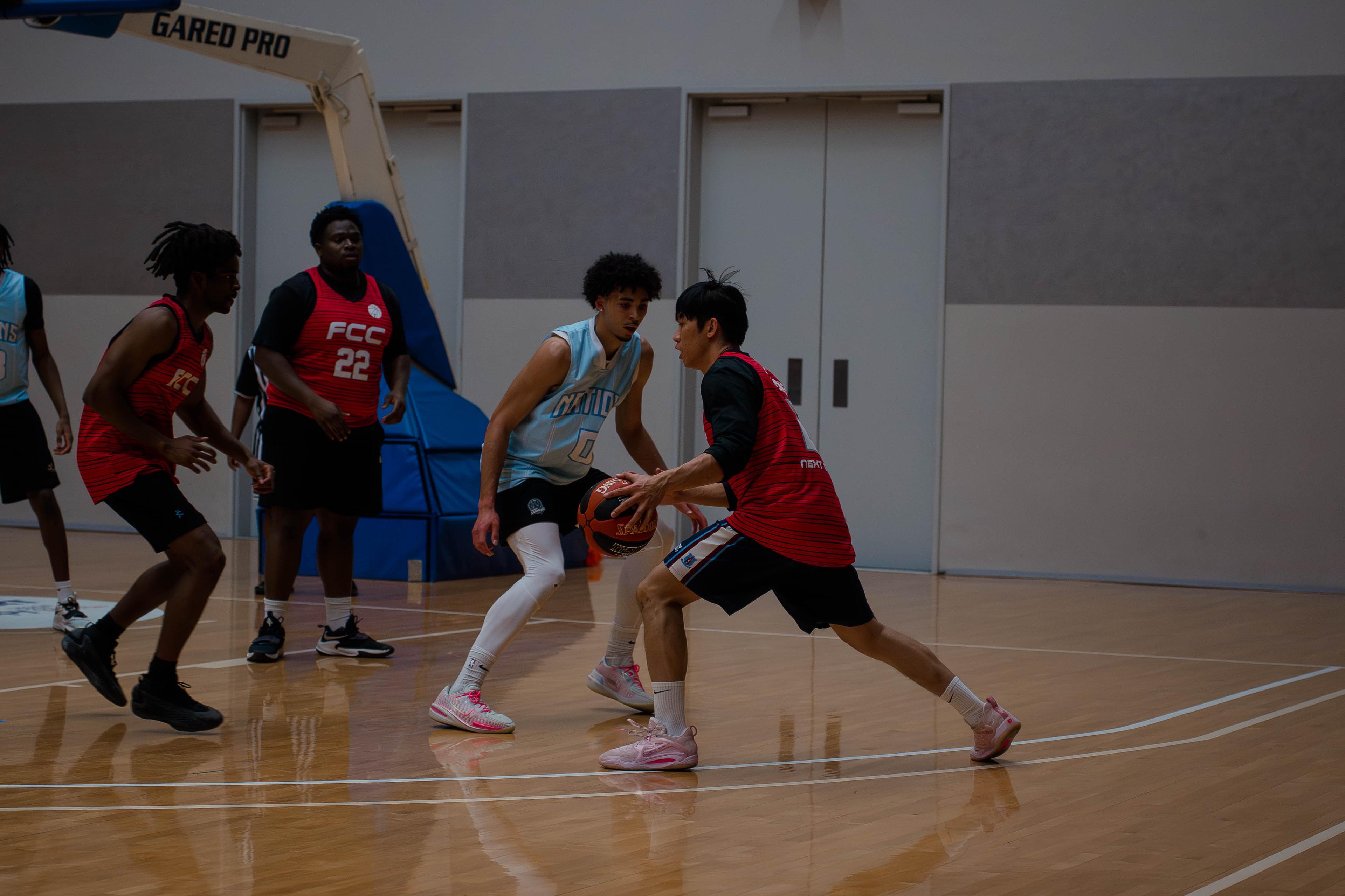 Ball-handler in light blue guarded closely by a defender during a CBL game.